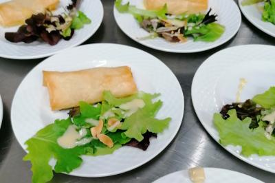 Assiette contenant du saumon fumé, crème, herbes fraîches et garnitures sur une sauce blanche.