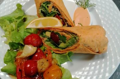 Assiette contenant du saumon fumé, crème, herbes fraîches et garnitures sur une sauce blanche.