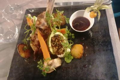 Assiette contenant du saumon fumé, crème, herbes fraîches et garnitures sur une sauce blanche.