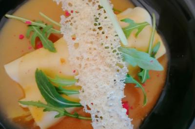 Assiette contenant du saumon fumé, crème, herbes fraîches et garnitures sur une sauce blanche.