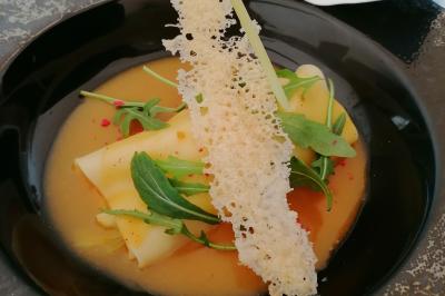 Assiette contenant du saumon fumé, crème, herbes fraîches et garnitures sur une sauce blanche.