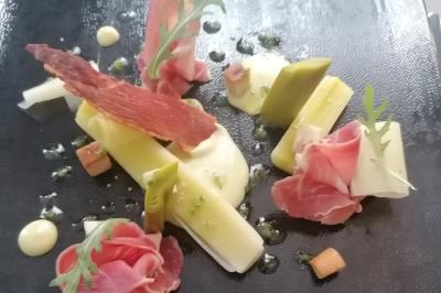 Assiette contenant du saumon fumé, crème, herbes fraîches et garnitures sur une sauce blanche.