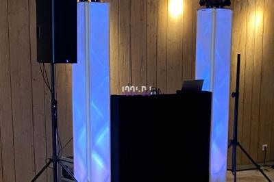 Un homme portant des écouteurs travaille sur un ordinateur portable dans un environnement faiblement éclairé.