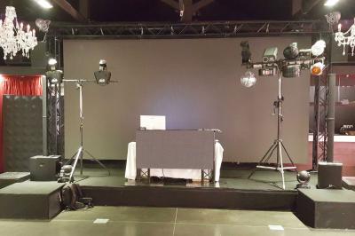 Un homme en costume est porté par une foule festive sous des guirlandes lumineuses, en extérieur de nuit.