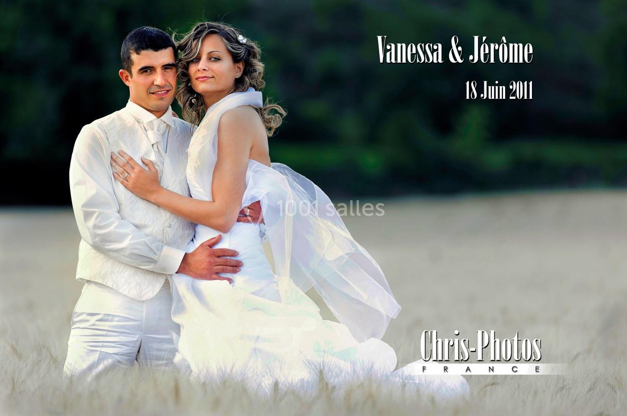 Un couple en tenue de mariage pose dans un champ avec un fond de verdure.