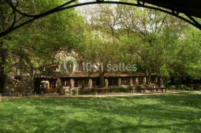 Table élégamment dressée avec chandeliers, verres, bouteilles de vin et serviettes pliées dans un cadre chaleureux.