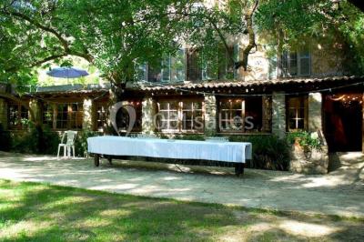 Table élégamment dressée avec chandeliers, verres, bouteilles de vin et serviettes pliées dans un cadre chaleureux.