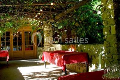 Table élégamment dressée avec chandeliers, verres, bouteilles de vin et serviettes pliées dans un cadre chaleureux.