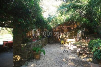 Table élégamment dressée avec chandeliers, verres, bouteilles de vin et serviettes pliées dans un cadre chaleureux.