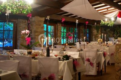 Table élégamment dressée avec chandeliers, verres, bouteilles de vin et serviettes pliées dans un cadre chaleureux.