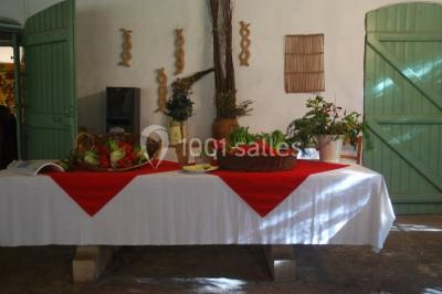 Table élégamment dressée avec chandeliers, verres, bouteilles de vin et serviettes pliées dans un cadre chaleureux.