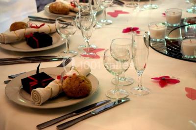 Table élégamment dressée avec chandeliers, verres, bouteilles de vin et serviettes pliées dans un cadre chaleureux.