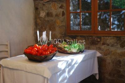 Table élégamment dressée avec chandeliers, verres, bouteilles de vin et serviettes pliées dans un cadre chaleureux.