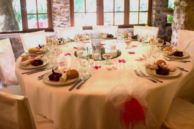 Table élégamment dressée avec chandeliers, verres, bouteilles de vin et serviettes pliées dans un cadre chaleureux.