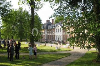 Groupe de personnes rassemblées dans un parc verdoyant lors d'un événement en plein air.