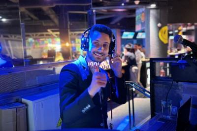 Main ajustant les réglages sur une table de mixage DJ illuminée par des lumières colorées.