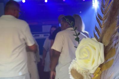 Main ajustant les réglages sur une table de mixage DJ illuminée par des lumières colorées.