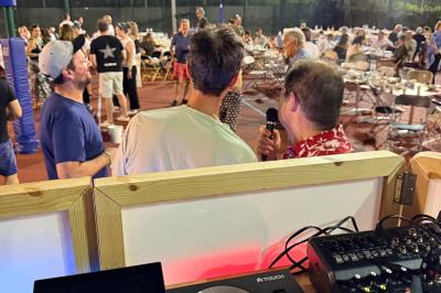 Main ajustant les réglages sur une table de mixage DJ illuminée par des lumières colorées.