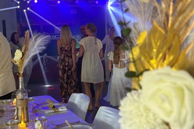 Main ajustant des réglages sur une table de mixage DJ lumineuse avec des écrans et des boutons colorés.