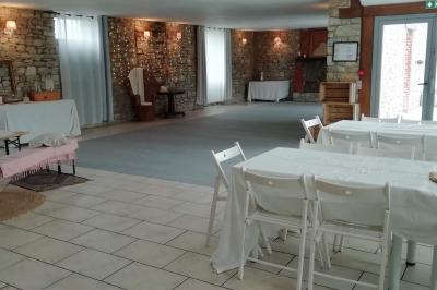 Miniature Location salle La Couyère (Ille-et-Vilaine) - La Demeure du Pont #4 Salle de réception lumineuse avec murs en pierre, tables rondes dressées de nappes blanches et décorations simples.