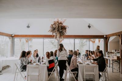 Miniature Location salle La Couyère (Ille-et-Vilaine) - La Demeure du Pont #15 Salle de réception lumineuse avec murs en pierre, tables rondes dressées de nappes blanches et décorations simples.