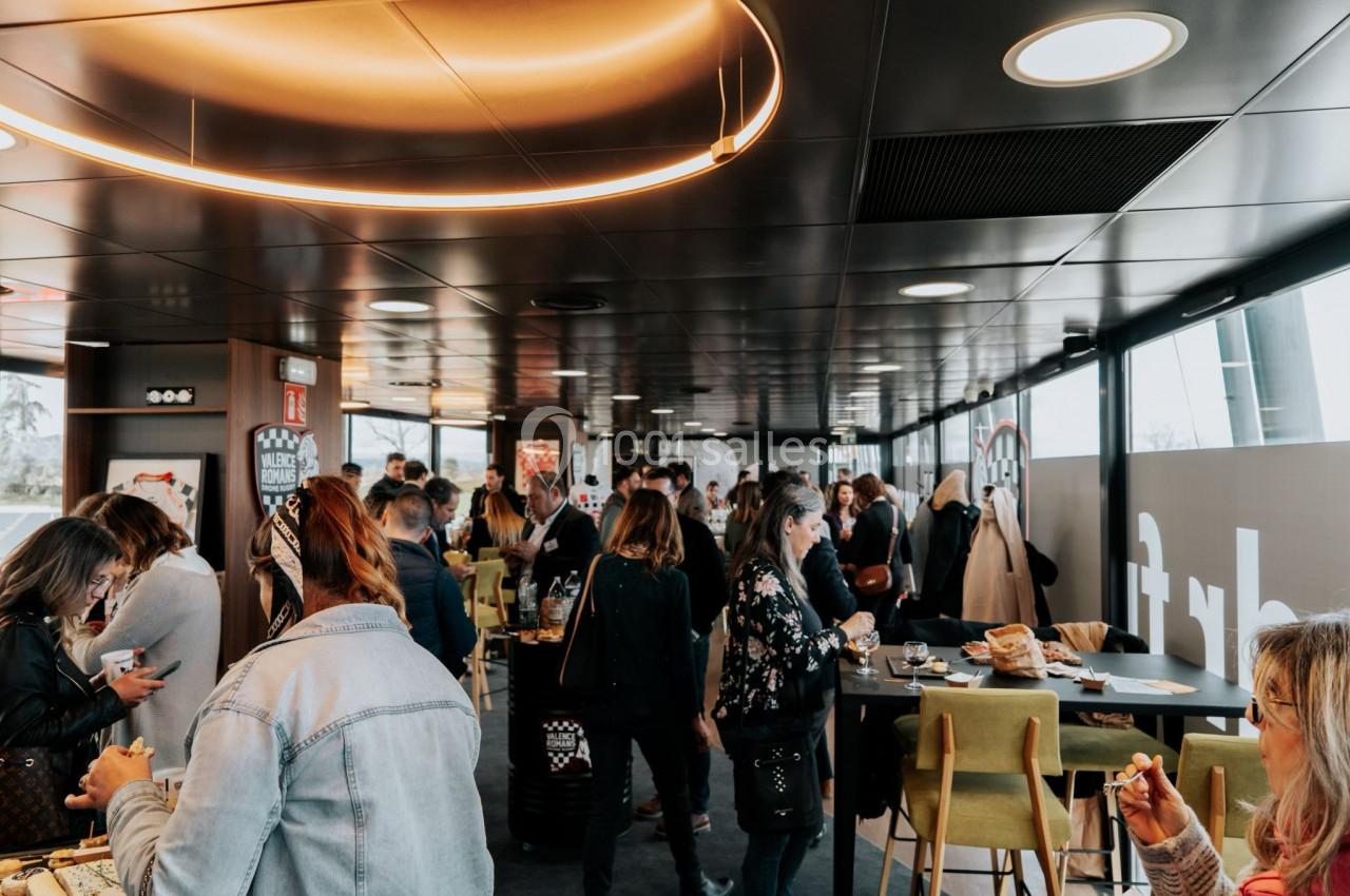 Personnes discutant et prenant un repas ou un café dans un espace lumineux avec des tables et des chaises modernes.