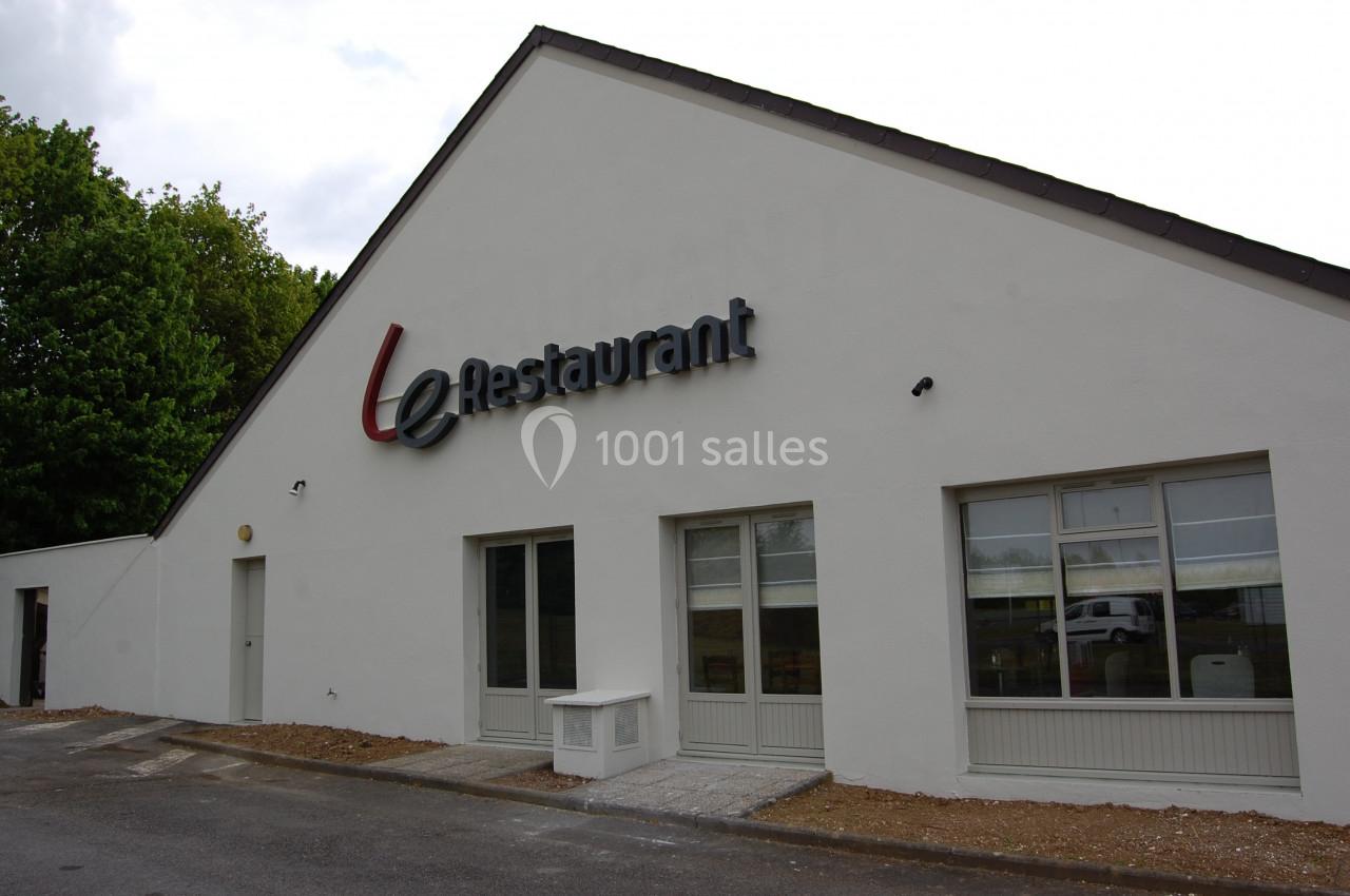 Façade d'un bâtiment blanc avec une enseigne ’Restaurant’ et plusieurs fenêtres vitrées.