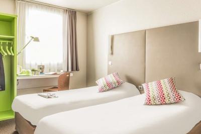 Salle de bain avec douche à paroi vitrée, lavabo suspendu, miroir éclairé et sol en carrelage foncé.