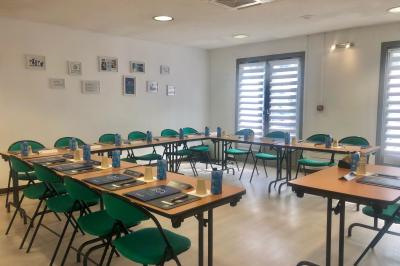 Salle de bain avec douche à paroi vitrée, lavabo suspendu, miroir éclairé et sol en carrelage foncé.