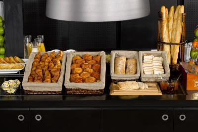 Chambre lumineuse avec un lit double, deux oreillers colorés, un bureau en bois et une lampe murale.