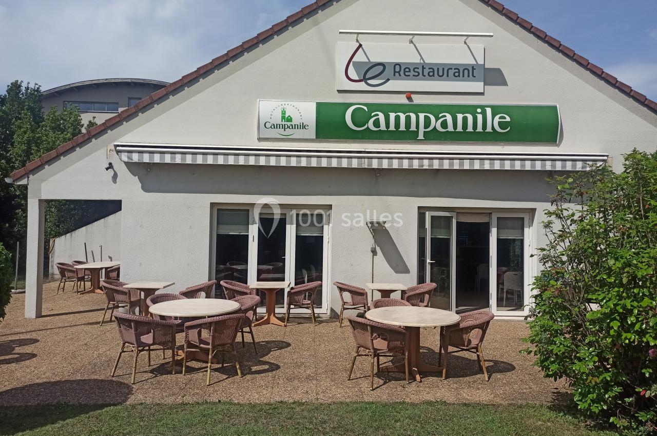 Façade d'un restaurant Campanile avec terrasse équipée de tables et chaises en plein air.