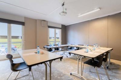 Façade d'un hôtel moderne avec balcons, entrée principale vitrée et enseigne ’Kyriad Hotel’.