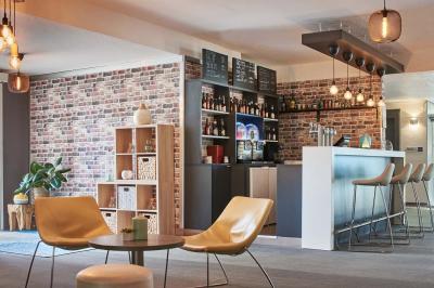 Façade d'un hôtel moderne avec balcons, entrée principale vitrée et enseigne ’Kyriad Hotel’.