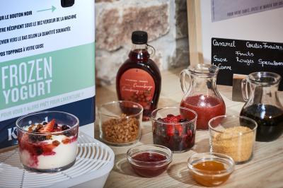 Chambre d'hôtel avec lit double, bureau équipé, lampe allumée et fenêtre avec rideaux marron.