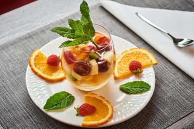 Chambre d'hôtel avec lit double, bureau équipé, lampe allumée et fenêtre avec rideaux marron.