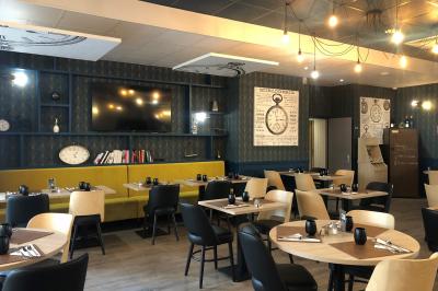 Salle de réunion avec tables disposées en U, bouteilles d'eau, stylos et blocs-notes sur chaque place.