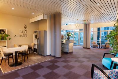 Salle de réunion avec tables disposées en U, bouteilles d'eau, stylos et blocs-notes sur chaque place.