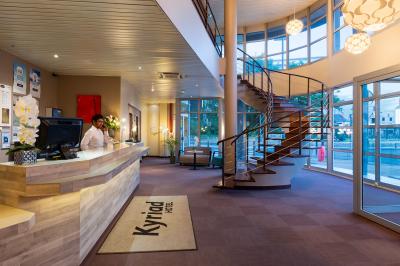 Salle de réunion avec tables disposées en U, bouteilles d'eau, stylos et blocs-notes sur chaque place.