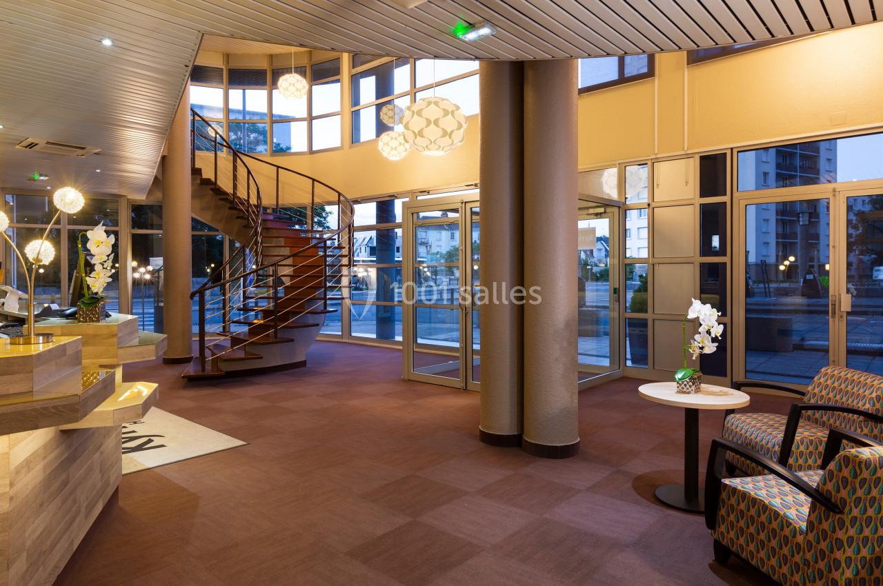 Hall d'entrée spacieux avec escalier en colimaçon, grandes baies vitrées et mobilier moderne.
