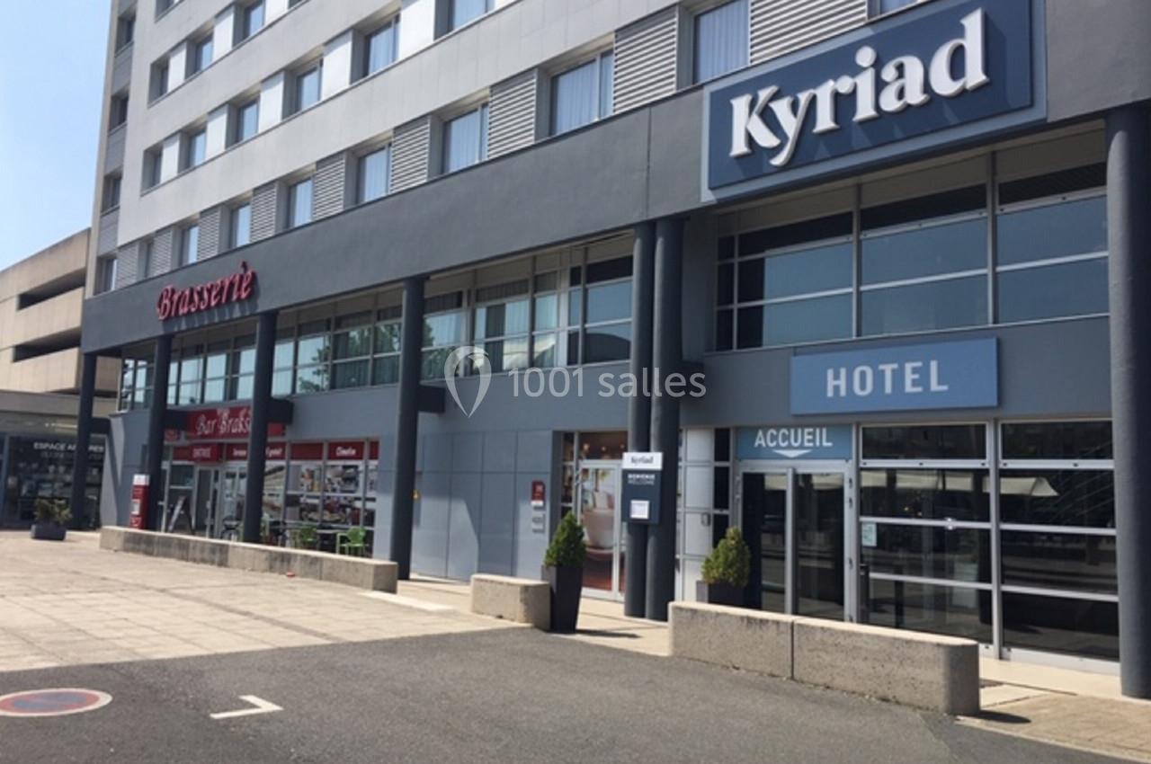 Façade d'un hôtel Kyriad avec une brasserie adjacente, situés au rez-de-chaussée d'un bâtiment moderne.