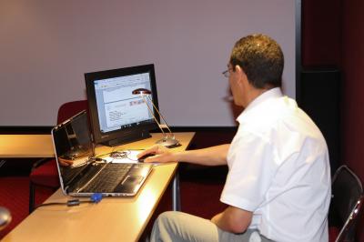 Un groupe de personnes pose devant une bannière, une femme au centre tient un diplôme.