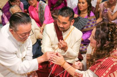Un couple en tenue de mariage danse sur une place pavée devant un bâtiment historique.