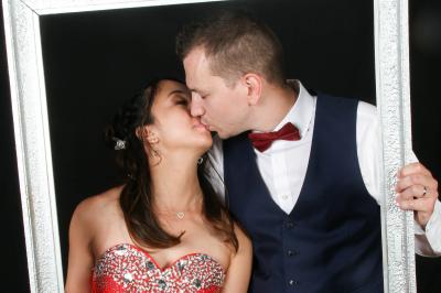 Un couple en tenue de mariage danse sur une place pavée devant un bâtiment historique.