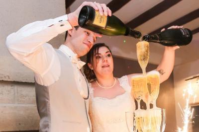 Un couple en tenue de mariage danse sur une place pavée devant un bâtiment historique.