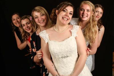 Un couple en tenue de mariage danse sur une place pavée devant un bâtiment historique.