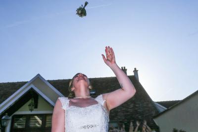 Un couple en tenue de mariage danse sur une place pavée devant un bâtiment historique.