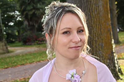Un couple en tenue de mariage danse sur une place pavée devant un bâtiment historique.