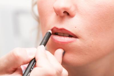 Un couple en tenue de mariage danse sur une place pavée devant un bâtiment historique.
