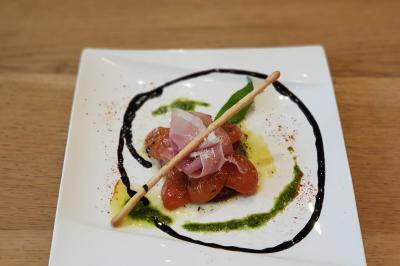 Assiette de salade composée avec magret de canard, carottes, fromage, framboise et feuilles de salade verte.