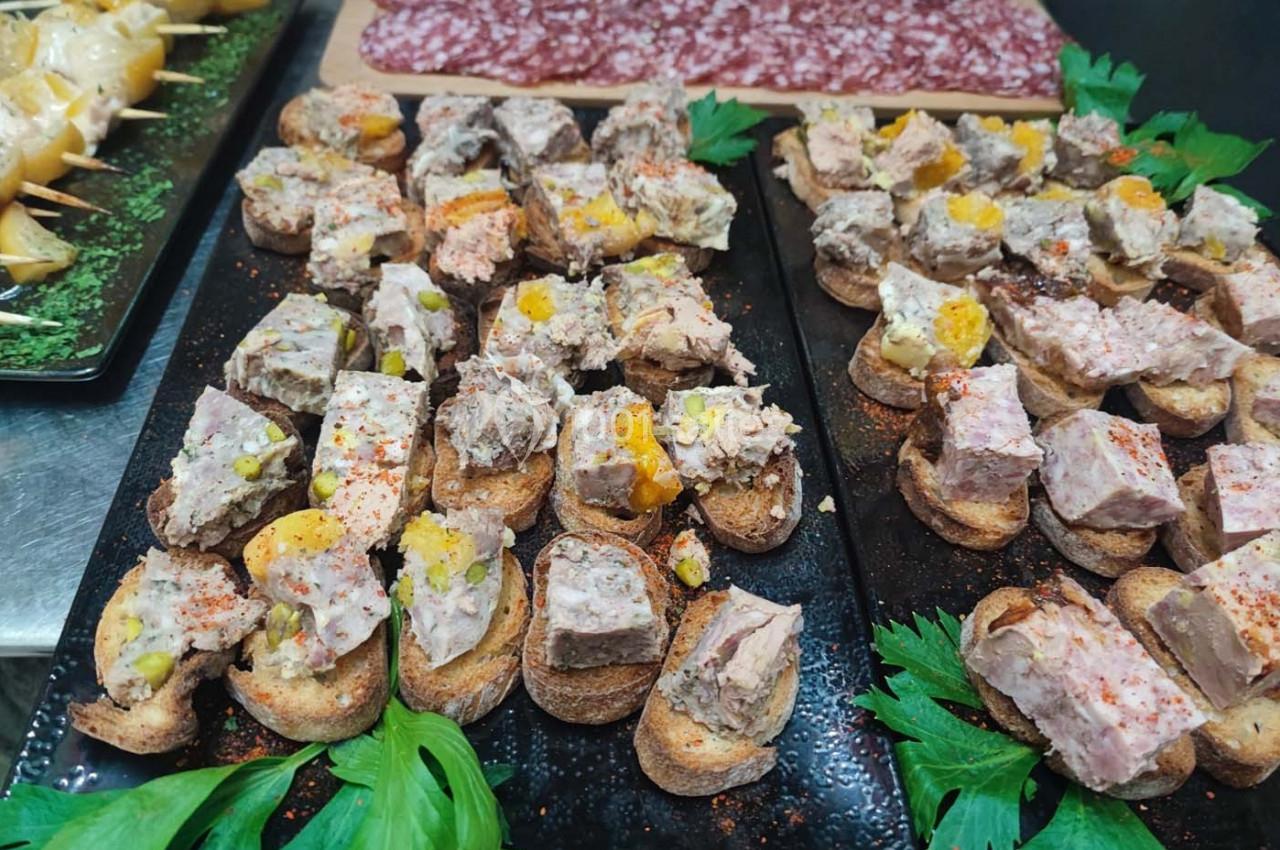 Plateaux de toasts garnis de pâtés variés et assaisonnés, accompagnés de feuilles de céleri en décoration.